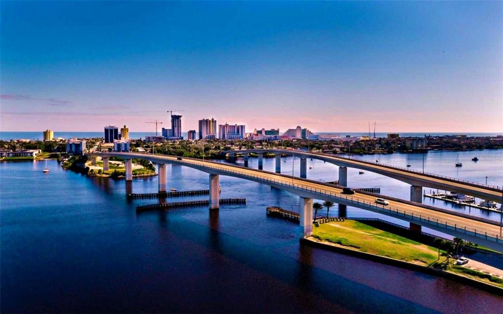 a bridge over a river with a city in the background at Wyndham Ocean Walk Resort - Vacation in Comfort by the sea - 2BR Oceanview 24320 in Daytona Beach