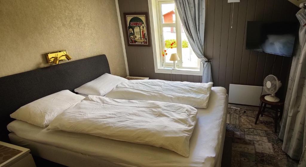 a bedroom with two beds with white sheets and a window at Øya husrom nær E6,dobbeltrom, gratis parkering in Sarpsborg