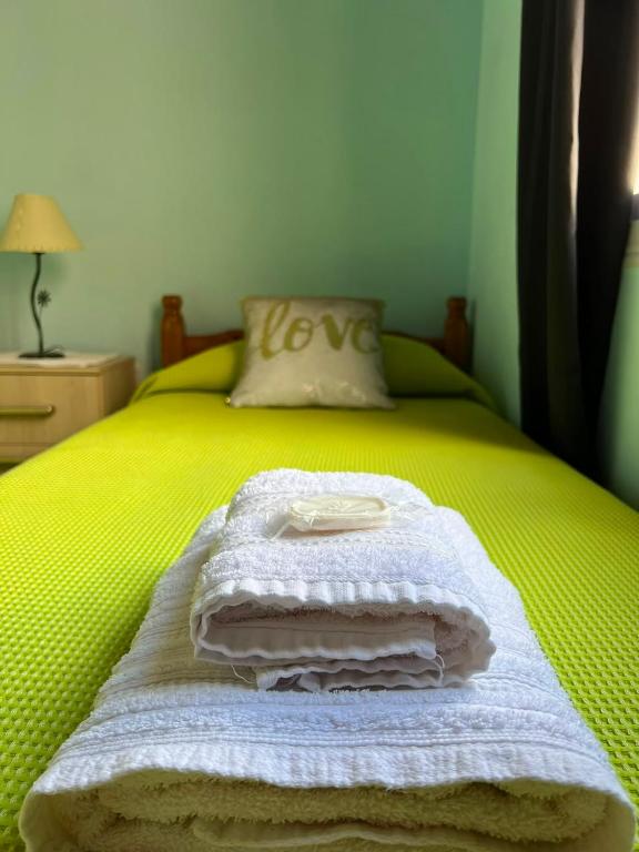 a yellow bed with white towels on it at Altos del Pissis I in Tinogasta
