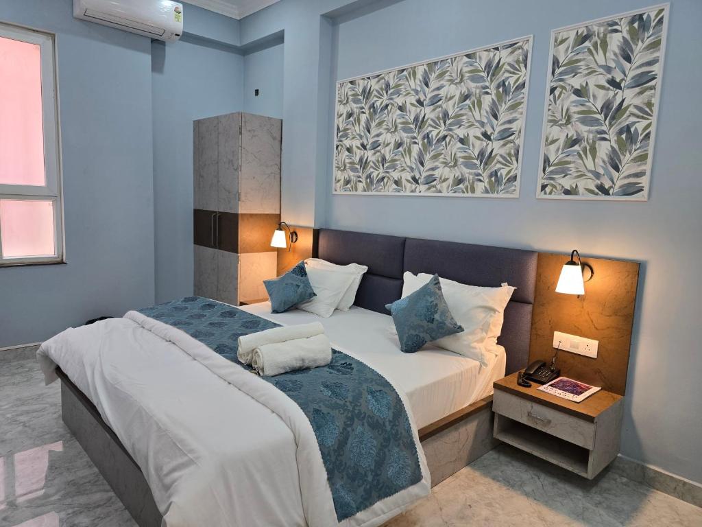 a bedroom with two beds with blue walls at Hotel Vatsalya by The Holy Meander in Varanasi