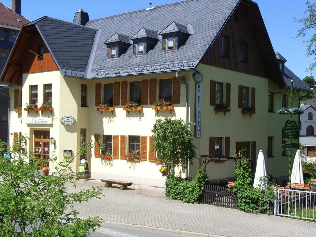 ein großes weißes Haus mit schwarzem Dach in der Unterkunft Gasthof zum Döhlerwald in Klingenthal