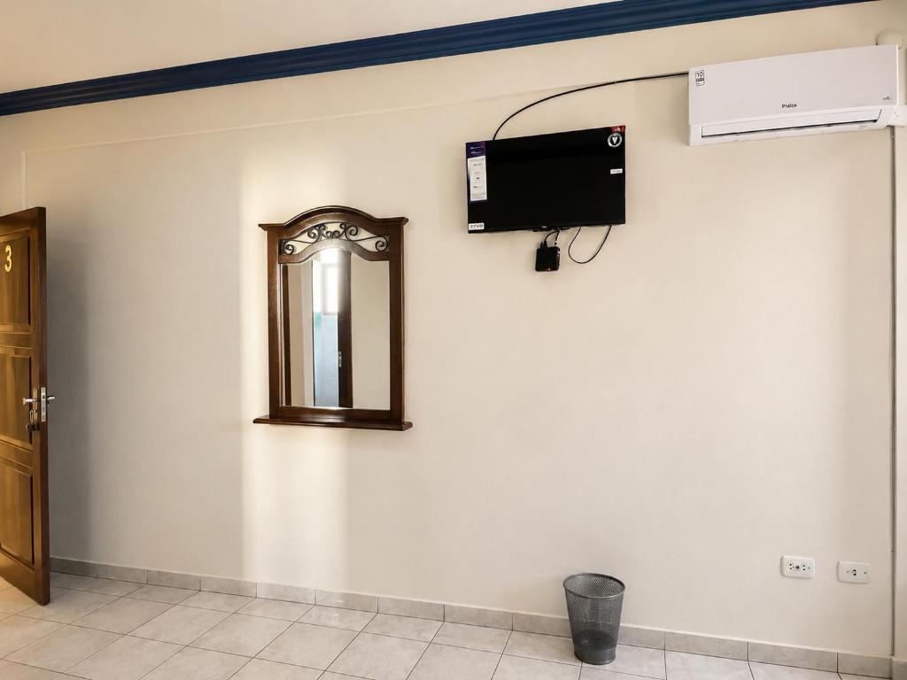 a mirror on a wall with a television on it at Alojamiento 22 dé octubre in Santa Cruz de la Sierra