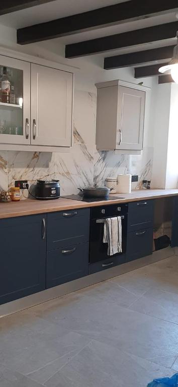 a kitchen with blue counters and white cabinets at Mulberry Tree Cottage Episkopi Paphos in Episkopi Pafou