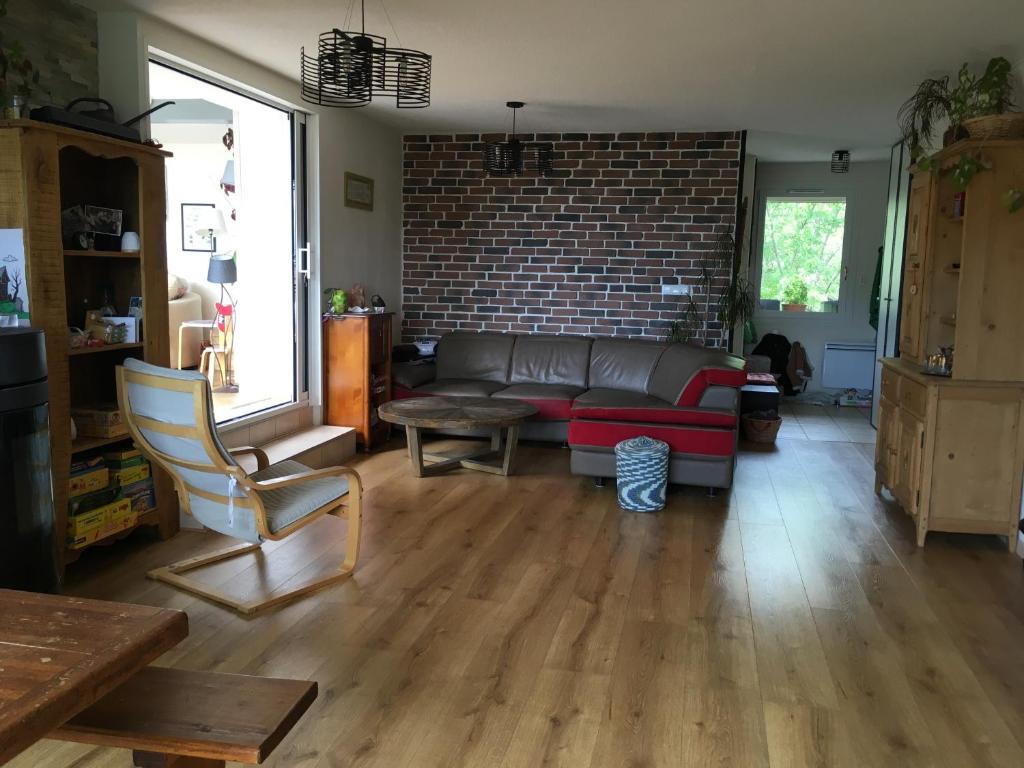 a living room with a couch and a brick wall at L'Hysope Gap, Maison d'hôtes contemporaine avec vue in Gap