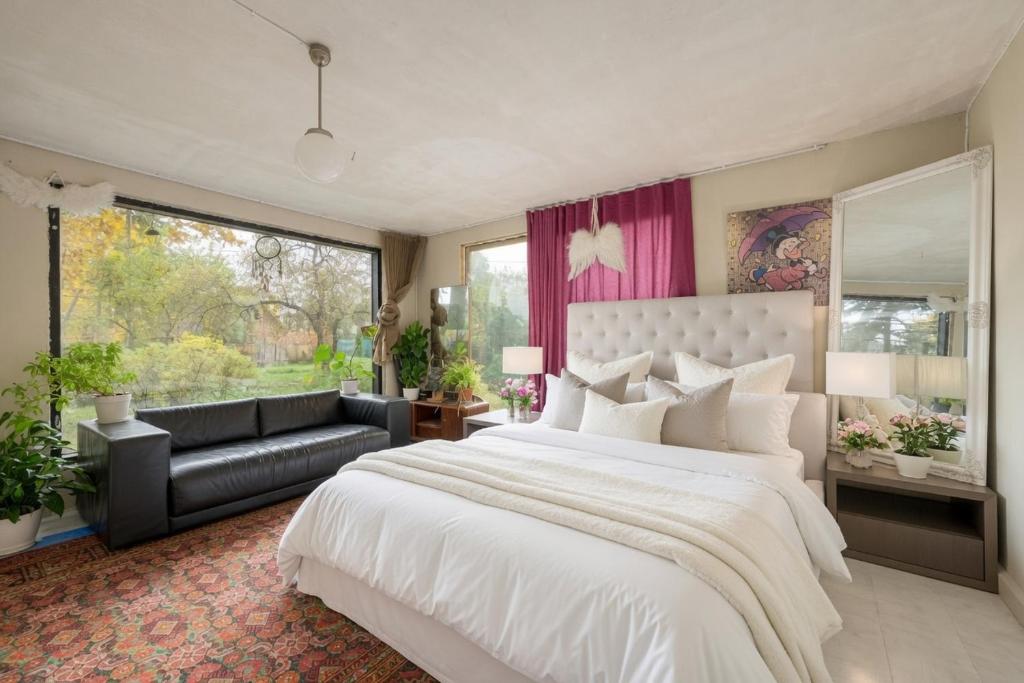 a bedroom with a large white bed and a couch at Zen Garden House in Võduvere