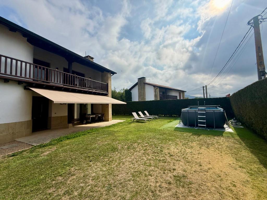 a backyard of a house with a appliance on the grass at La casa de Nino in Cabanzón