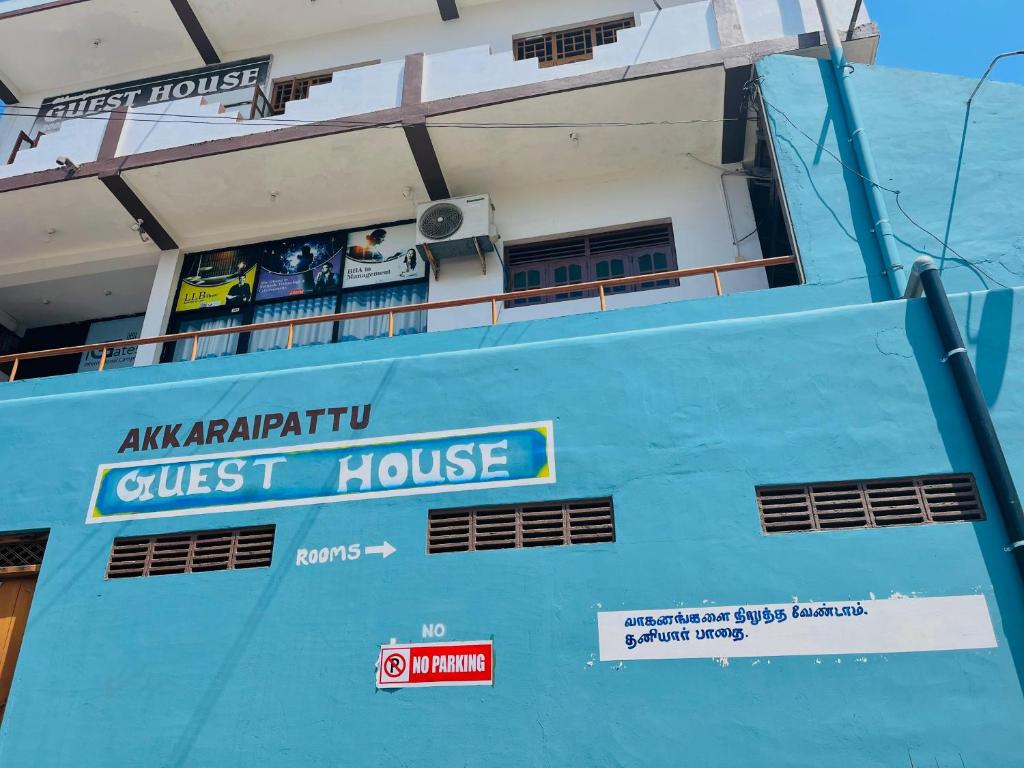 a blue cruise ship in front of a building at Akkaraipattu Guest House in Akkaraipattu