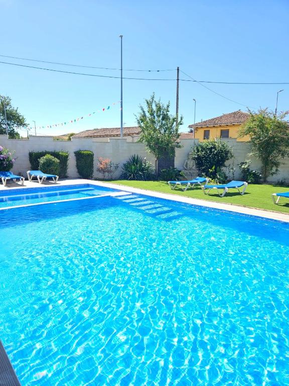 a large swimming pool with blue water in a yard at Lavanda Natur León3 Apartment 5 Pers in Villafañé