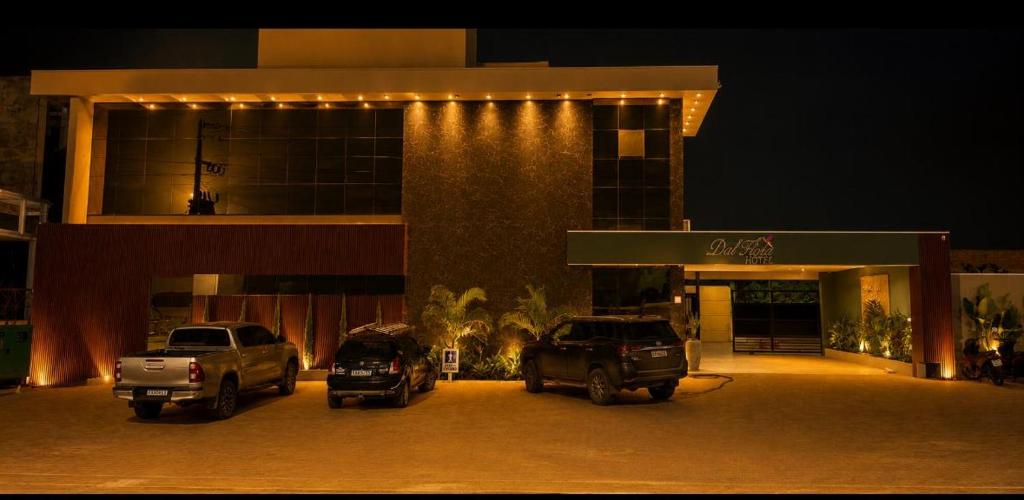 two cars parked in front of a building at night at Hotel Dal Flora in Sorriso