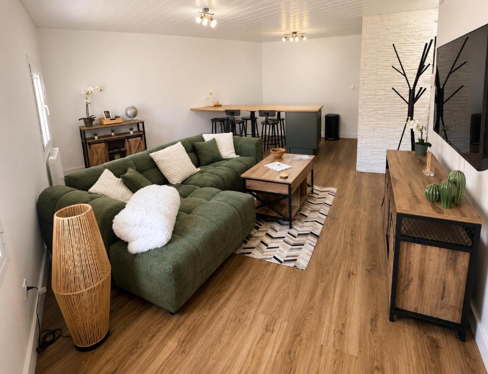 a living room with a green couch and a table at Résidence de la Place in Pont-du-Château