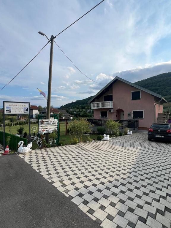 a parking lot with a car and a building at Apartman Demirovic in Orašac