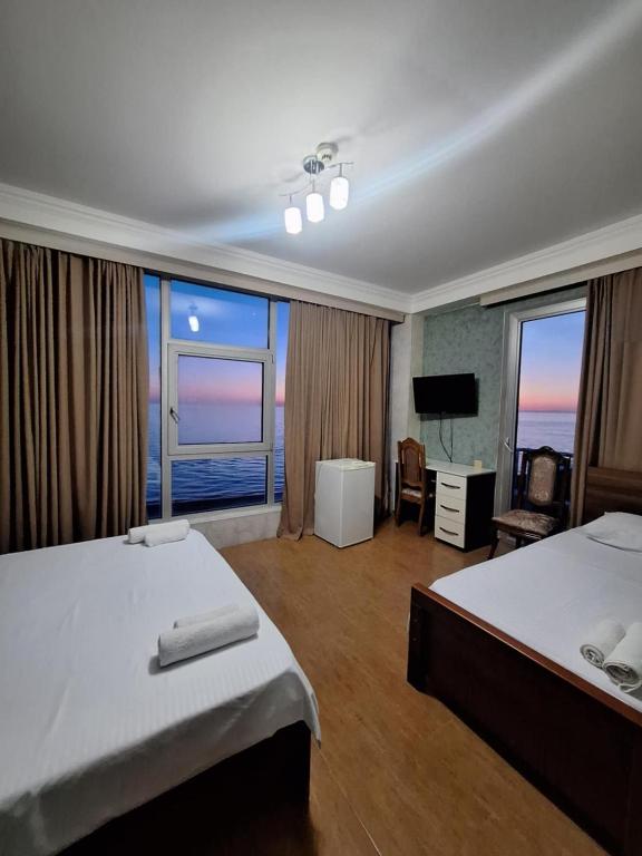 a hotel room with two beds and a television at Hotel Olimp in Shekhvetili