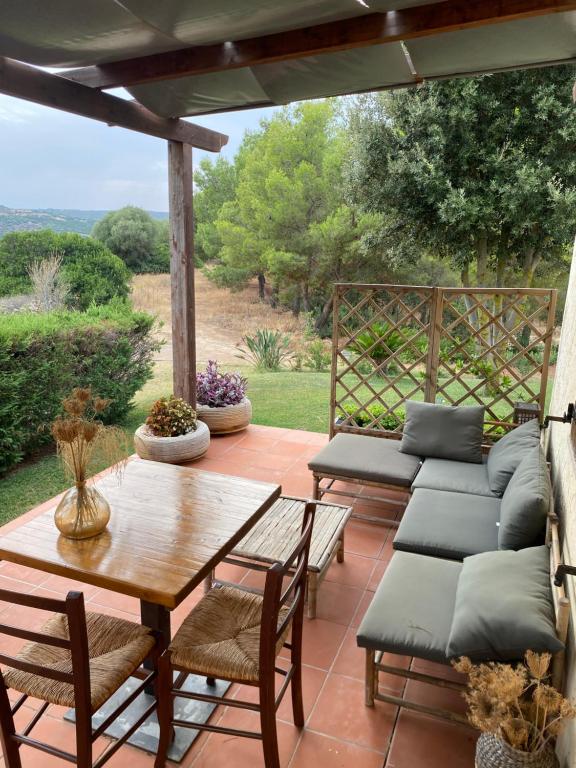a patio with a table and chairs and a couch at Wild sud Sardinia 3 in Teulada