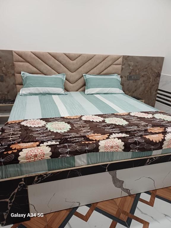 a bed with a quilt on top of it at Shreeji Nikunjdham in Vrindāvan