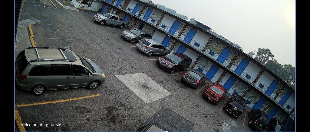 a group of cars parked in a parking lot next to a building at Riviera motel in Detroit