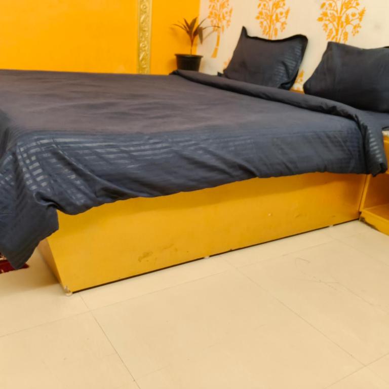 a bed with a yellow bed frame in a room at Gurudeva stay inn in Covelong