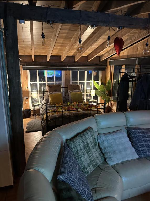 a living room with a blue leather couch and pillows at Scarthingmoor Lodges in Weston