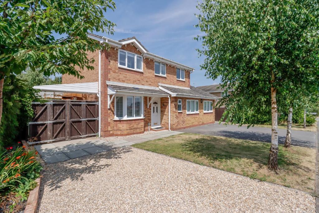 a brick house with a garage and a tree at Stylish Cheshire House in Winsford