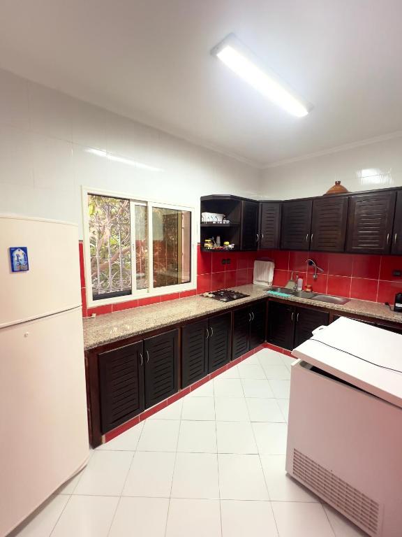 a kitchen with black cabinets and a white tile floor at Villa Yassir expert Cabo in Cabo Negro