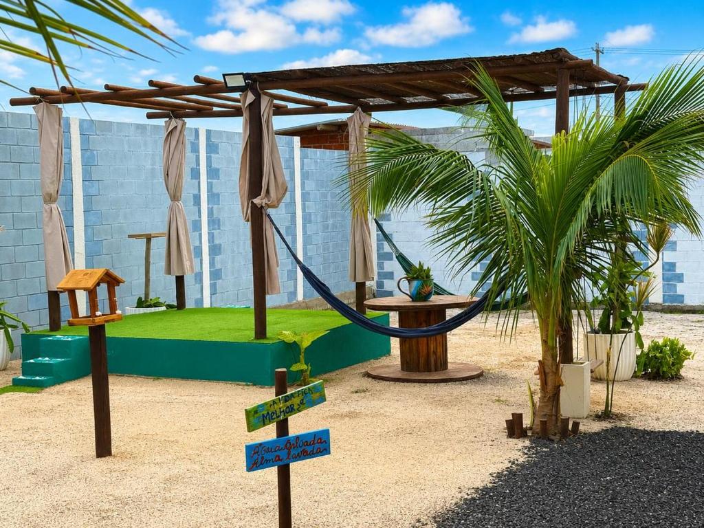a hammock in a resort with a palm tree at Canto das Praieiras - Porto de Sauípe, Rio & Mar in Porto de Sauipe
