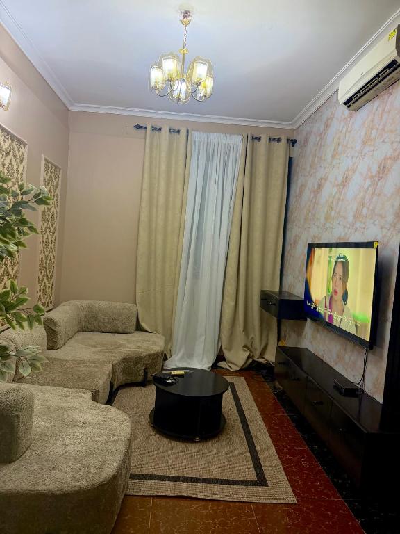 a living room with a couch and a tv at Alpha serenity in Mwanza