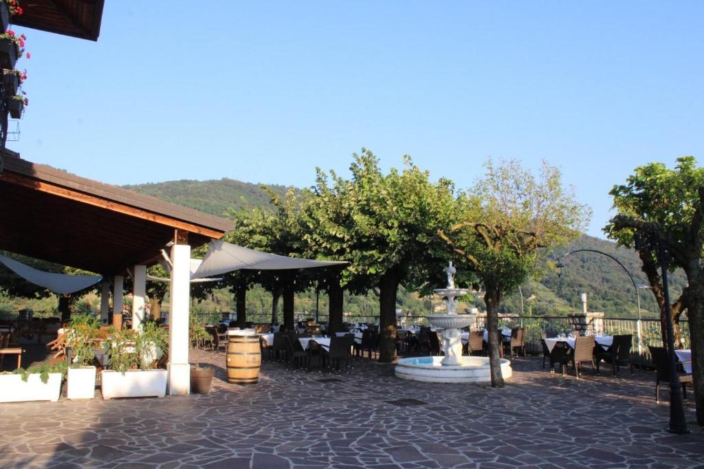 a restaurant with a fountain and tables and chairs at Hotel Ristorante San Michele in Ome