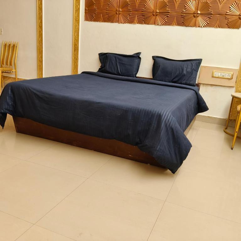 a bedroom with a bed with blue sheets and pillows at Adory homes inn in Kelambākkam