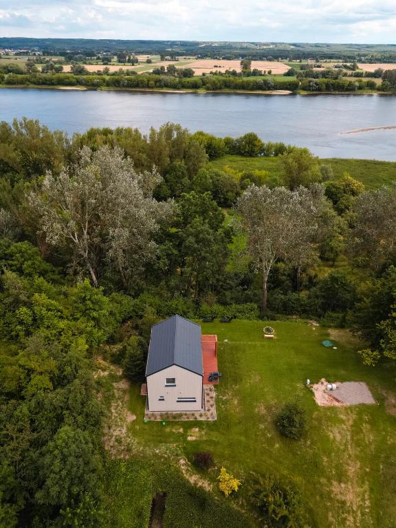 an overhead view of a house on a field next to a river at PrzyStań w Ciszy in Kozielec