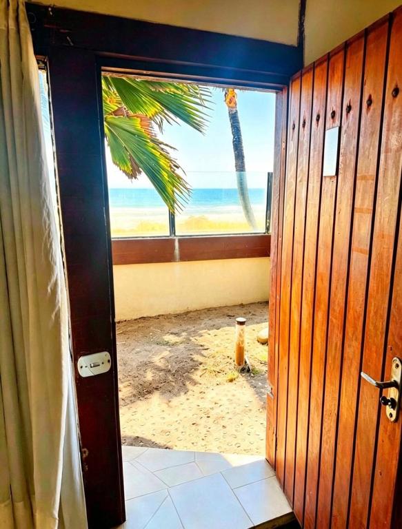 a door to a room with a view of the beach at Beachfront suite right on the sand in Cabo Frio