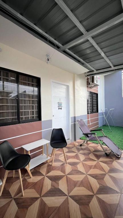 a room with two chairs and a table and a bench at Thad Transient House - Gensan in General Santos