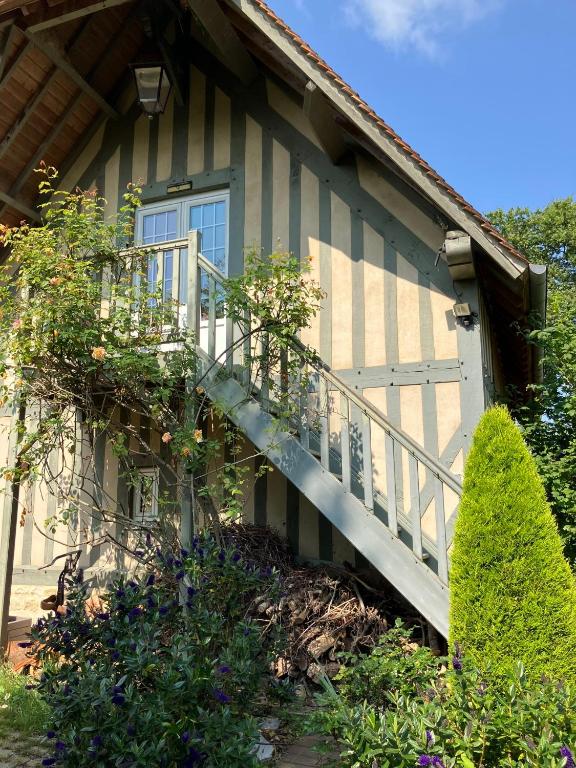 a house with a staircase leading to a door at L'Ecrin Normand appartement avec jardin comportant 2 lits 2 places et 1 lit 1 place in Cambremer