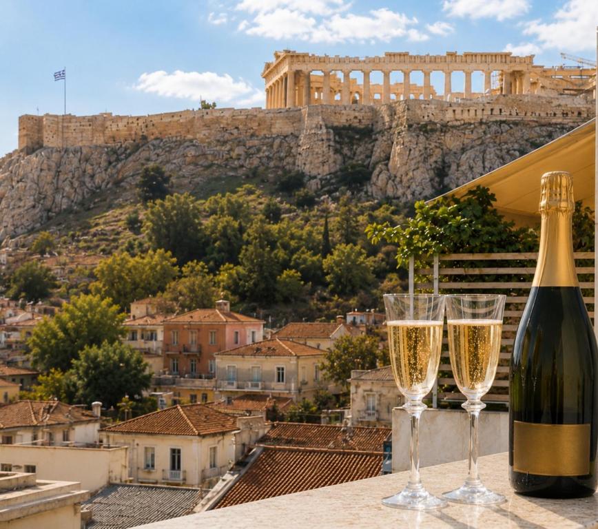 a bottle of wine and two glasses on a ledge at Ermou w Jacuzzi Acropolis View Monastiraki in Athens
