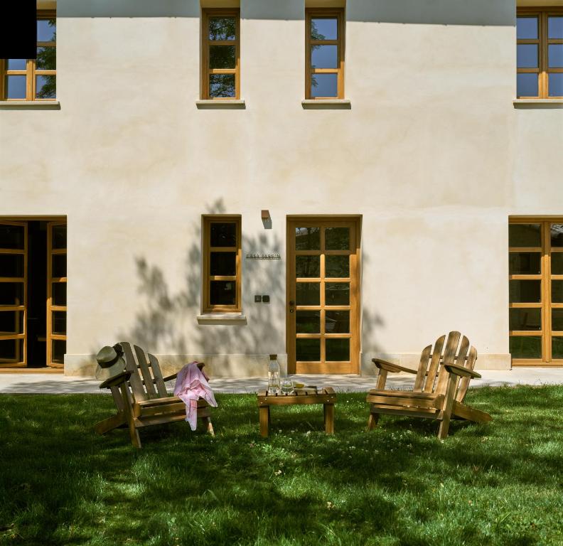 two chairs and a table in the grass in front of a building at Otegui Etxea Casa Rural in Aspuru