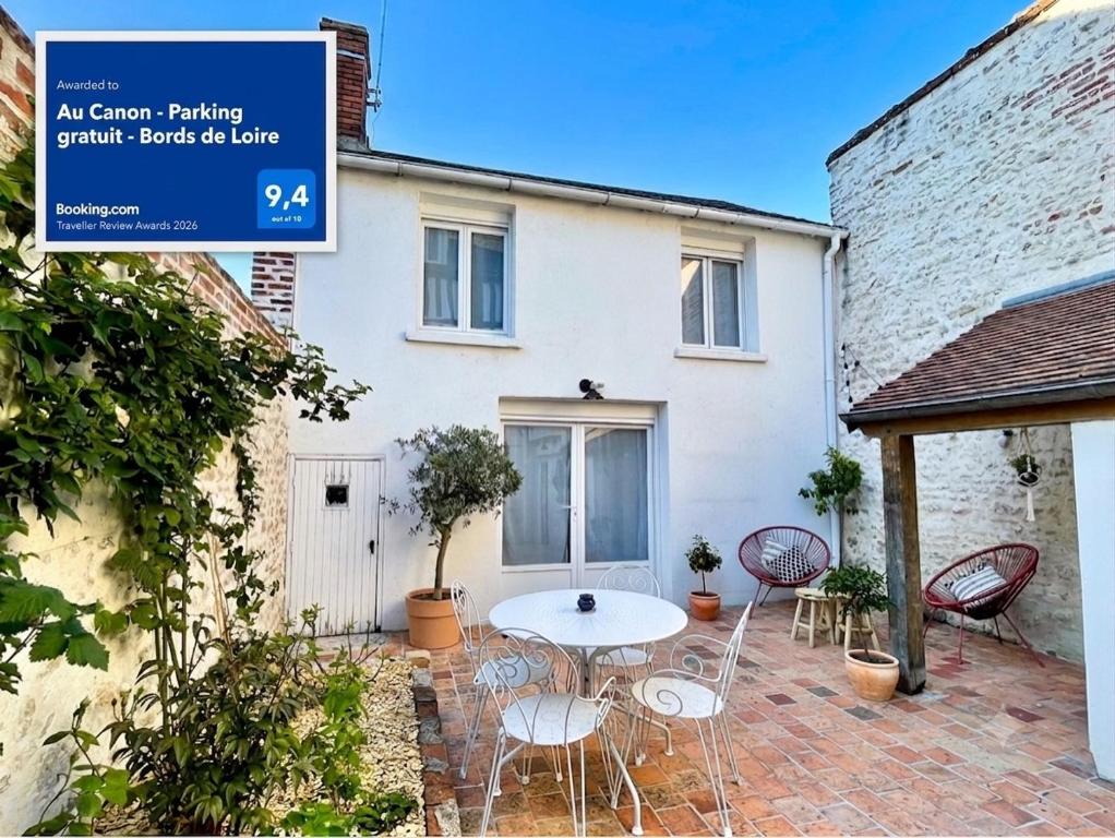 a patio with a table and chairs in front of a house at Au Canon - Parking gratuit - Bords de Loire in Orléans