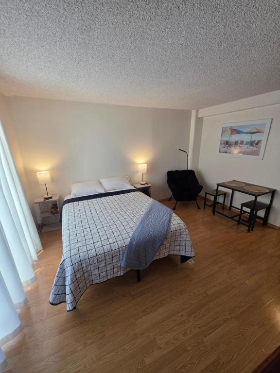 a bedroom with a bed and a desk and a table at Waikiki Vacation Apartment in Honolulu