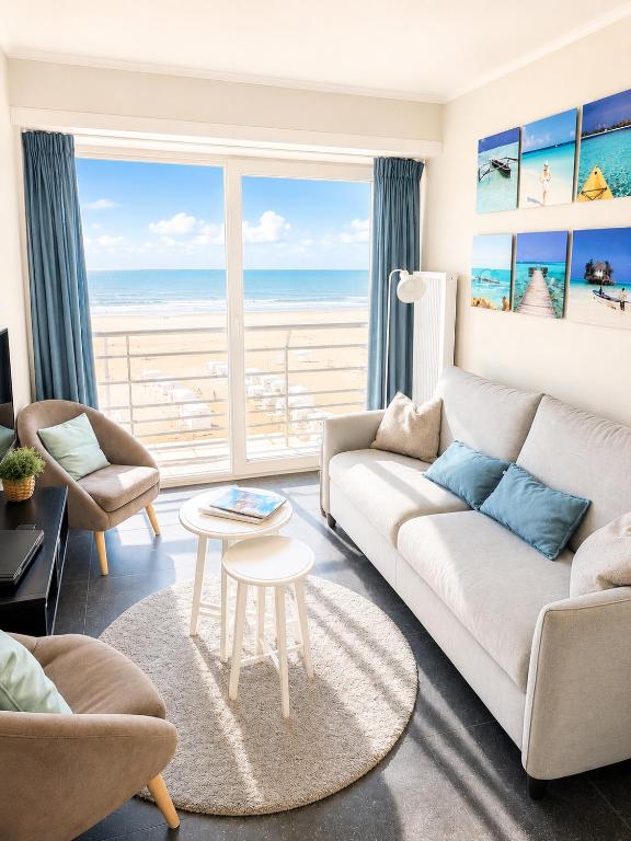 a living room with a couch and a view of the ocean at De Zandkorrel - Amazing seaview in Wenduine