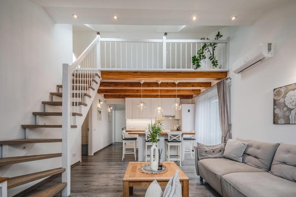 a living room with a staircase and a dining room at Gerika guest house in Palanga