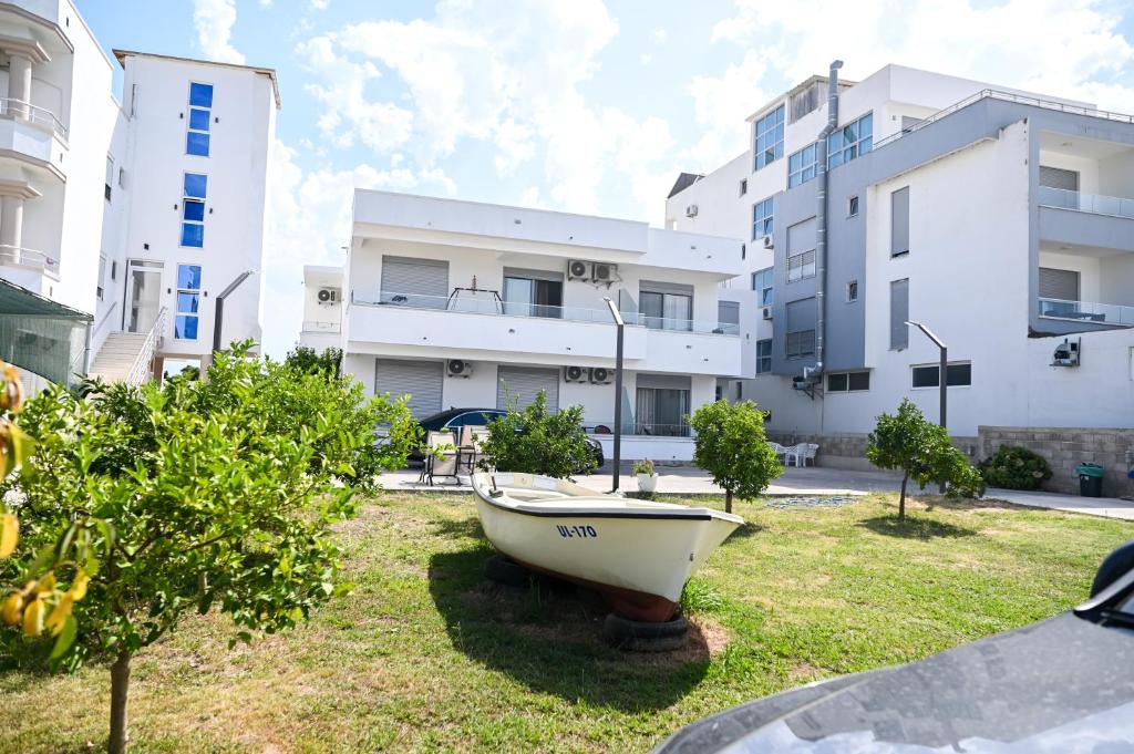 a small boat in the grass in front of buildings at Apartman Amin&Amina in Ulcinj
