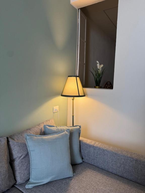 ein Wohnzimmer mit einer Couch mit Kissen und einer Lampe in der Unterkunft Chagall Blangè in Asti