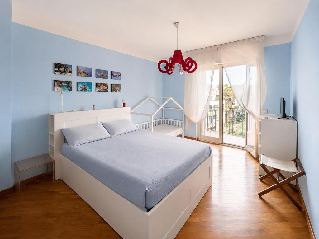 a bedroom with a white bed and a window at il grippiale in Aci Castello