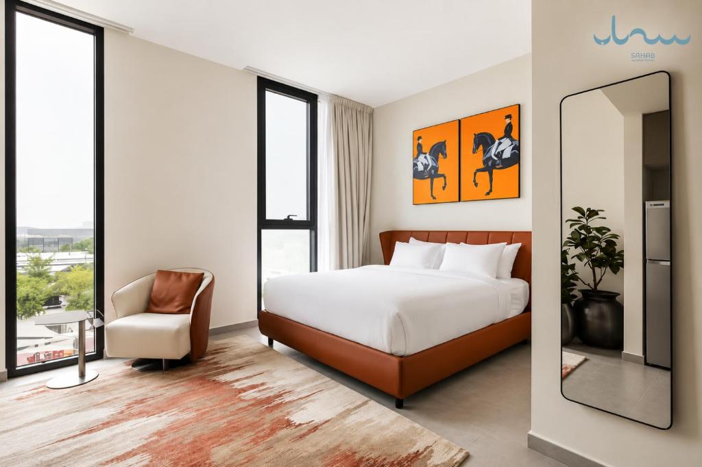a hotel room with a bed and a chair at Sahab - Hermes Leather Home in Sharjah