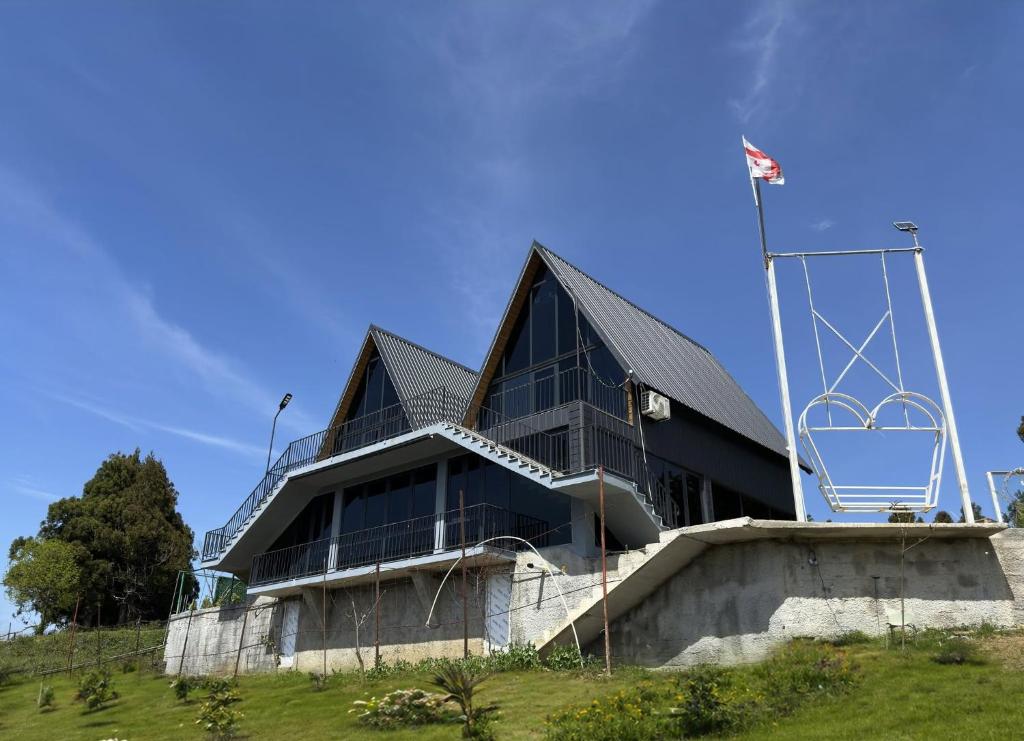 a building on top of a hill with a flag at Casa Verde&Mare in Sharabidzeebi