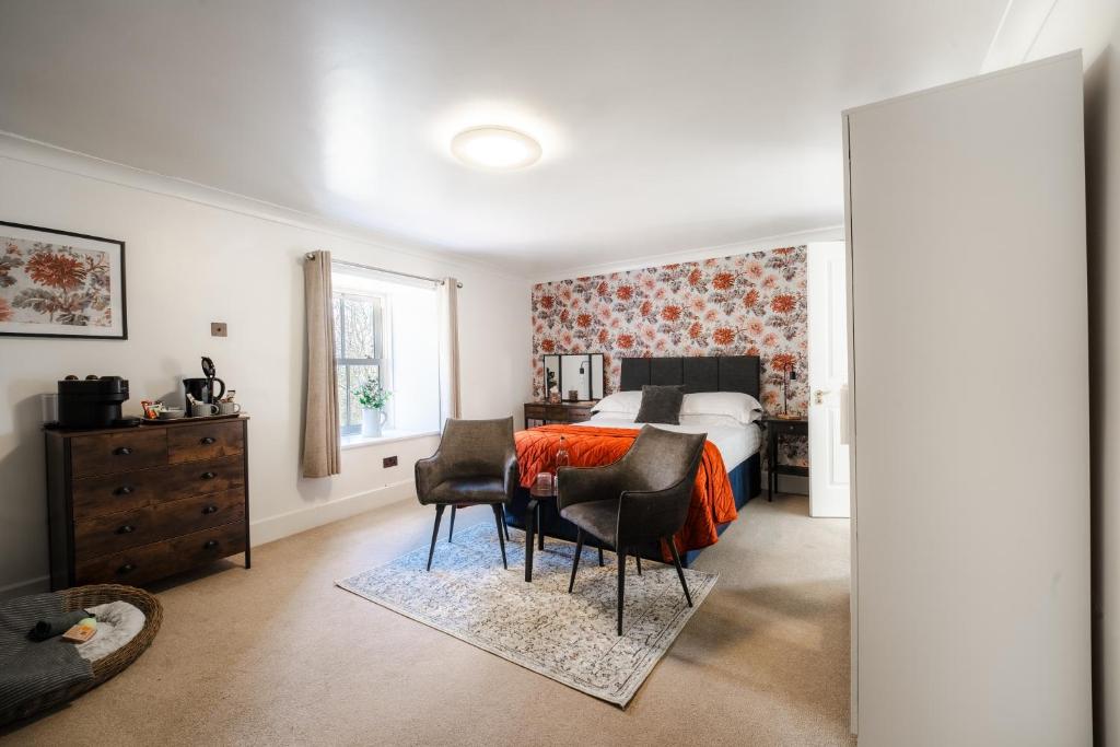 a bedroom with a bed and a table and chairs at Redesdale Arms in Otterburn