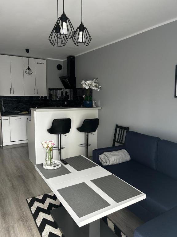 a living room with a blue couch and a table at Apartament w Dolinie Baryczy in Milicz