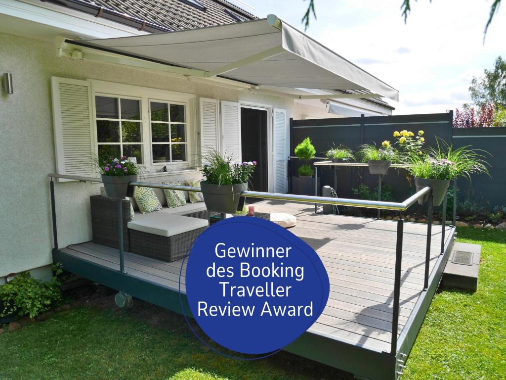 a deck with awning and potted plants on a house at Landhaus SoonZauber - Exklusives Paar-Hideaway im Naturpark Soonwald-Nahe in Münchwald