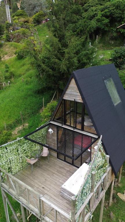ein kleines Haus mit schwarzem Dach auf einer Terrasse in der Unterkunft NatuGlamp in Medellín