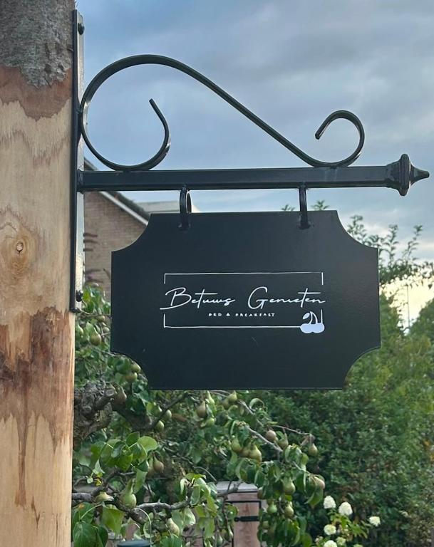 a sign hanging from the side of a building at Bed & Breakfast Betuws Genieten in Tiel