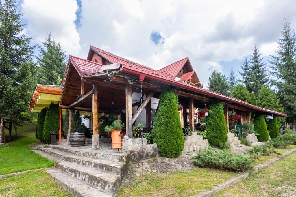 a house with a red roof and stairs at Casa Valasoaia in Săcele