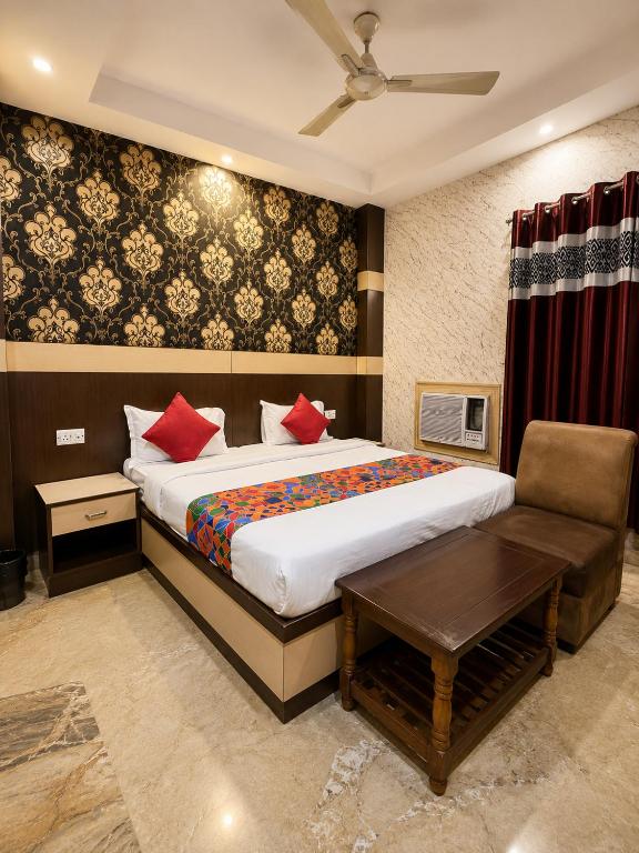 a bedroom with a bed and a table and a couch at Hotel Crystal Inn in Lucknow