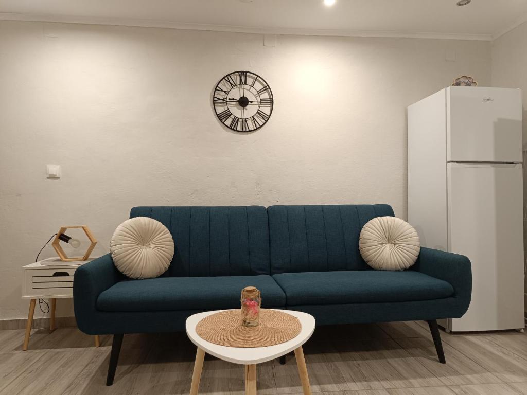 a blue couch in a living room with a clock at LA CASA Di GIORGIO in Pentátion